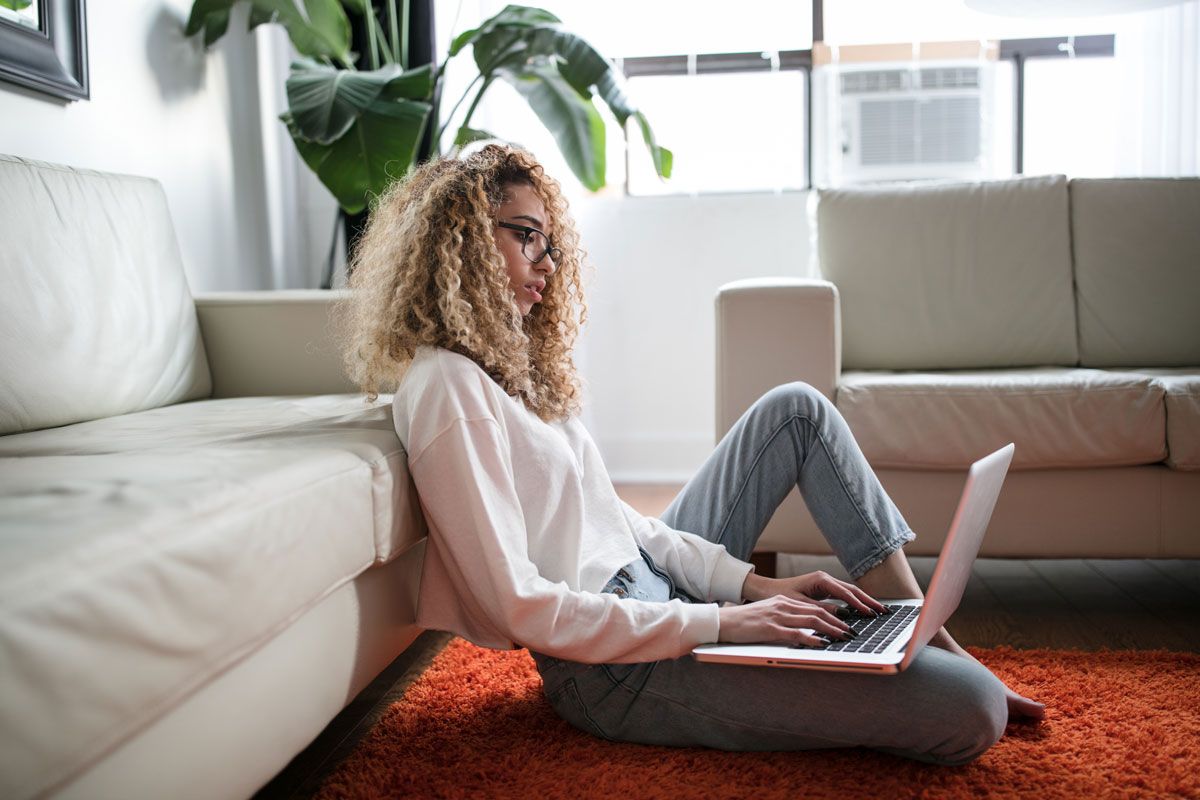 Woman sitting on floor using laptop