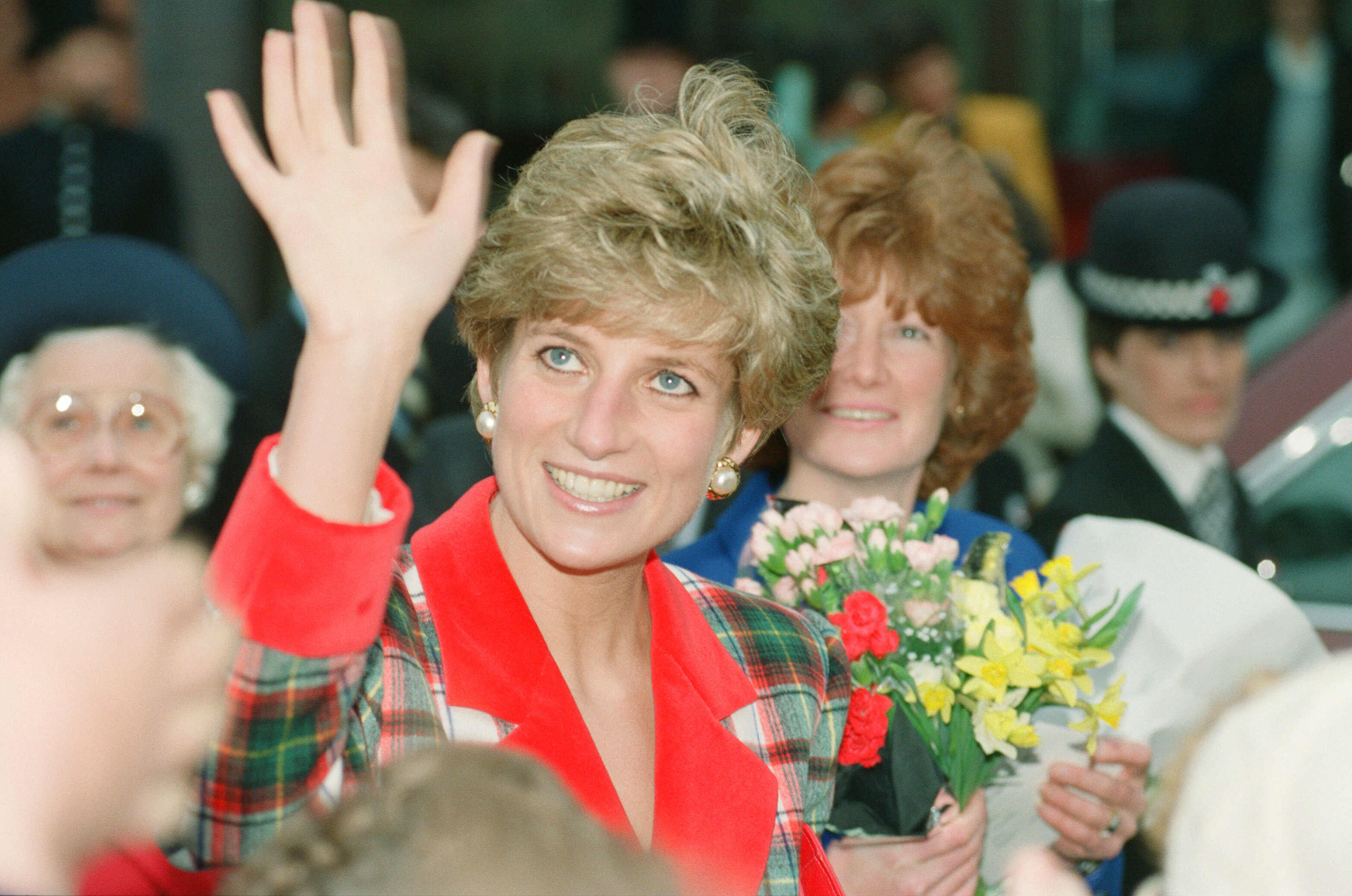 Princess Diana waving in a red and green blazer