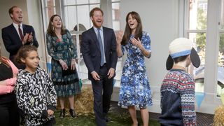 Prince Harry and Kate Middleton laughing during an engagement