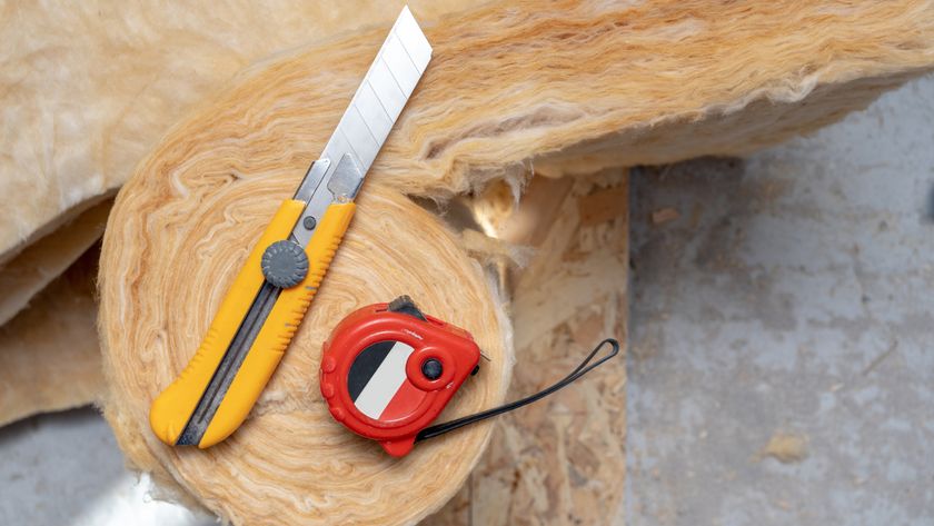 roll of insulation with stanley knife and tape measure