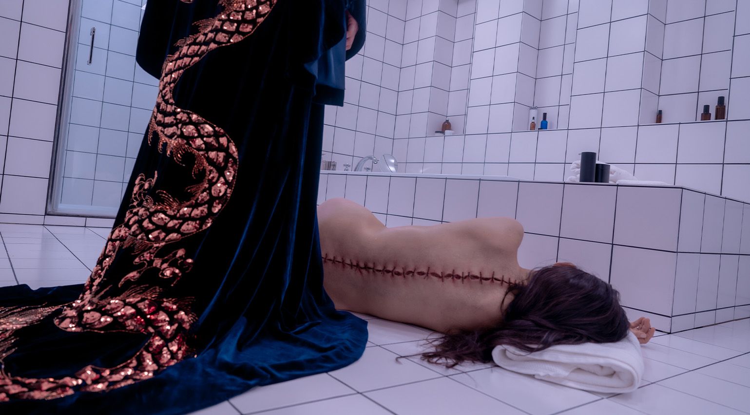 film still showing woman with stitches down back