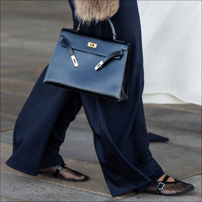 A guest at fashion week walks down the sidewalk in a pair of mesh ballet flats to illustrate a guide to the best mesh flats