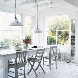 White table and chairs in a white room overlooking the garden