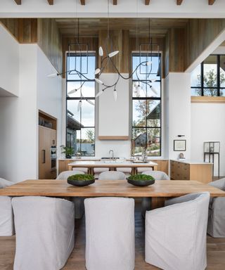 dining space white walls white covered chairs wood paneled ceiling