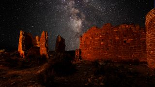 hovenweep national monument at night with the milky way behind.