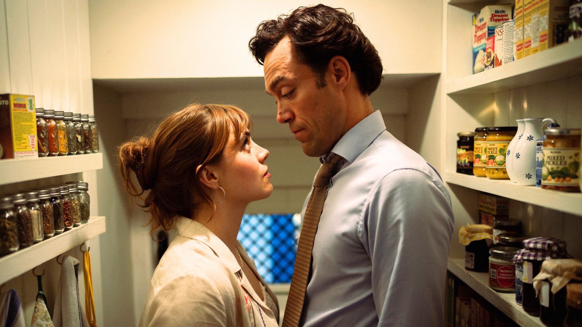 Taggie and Rupert look at each other while standing in a pantry