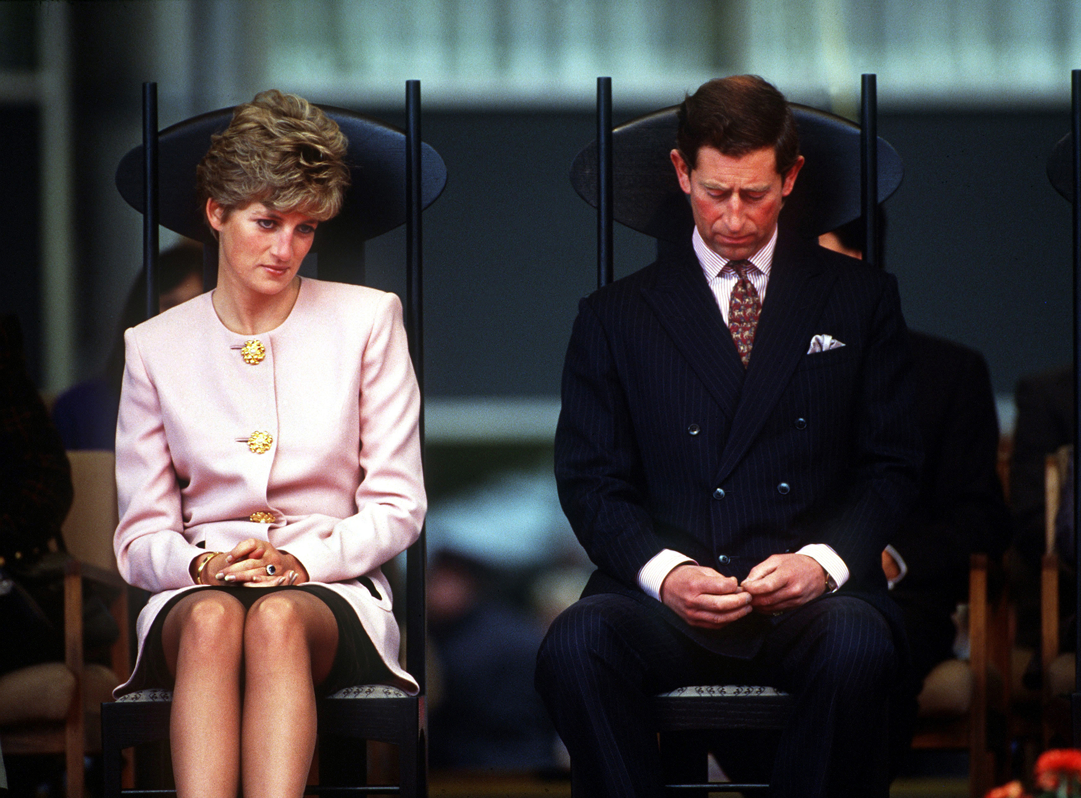 Princess Diana and Prince Charles sitting in chairs looking sad