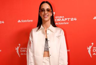 Caitlin Clark wearing a Prada white satin set and black accessories at the 2024 WNBA Draft.