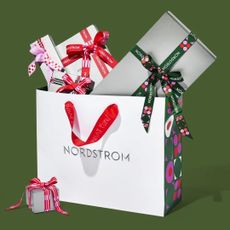 Nordstrom bag with wrapped gifts on green background