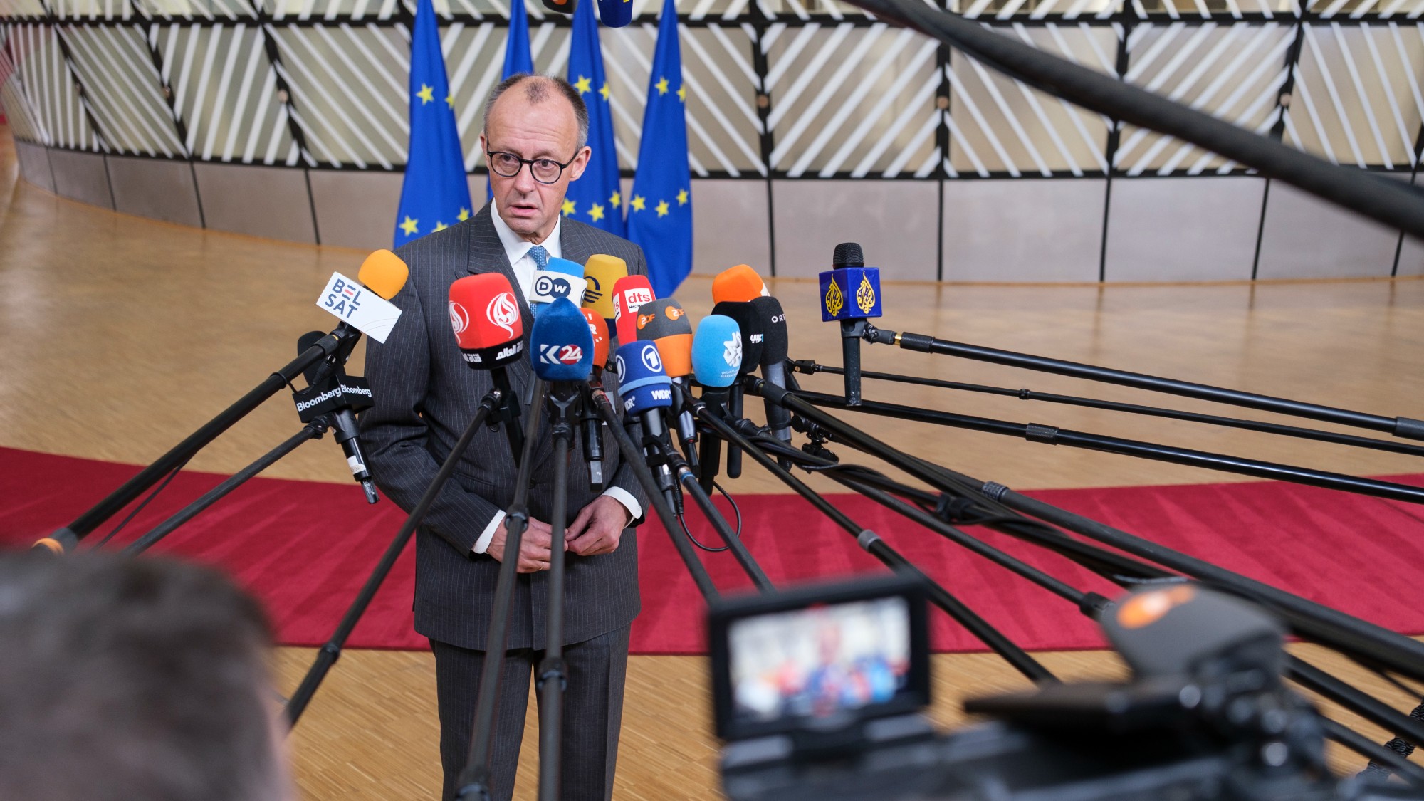 Friedrich Merz in front of reporters' microphones