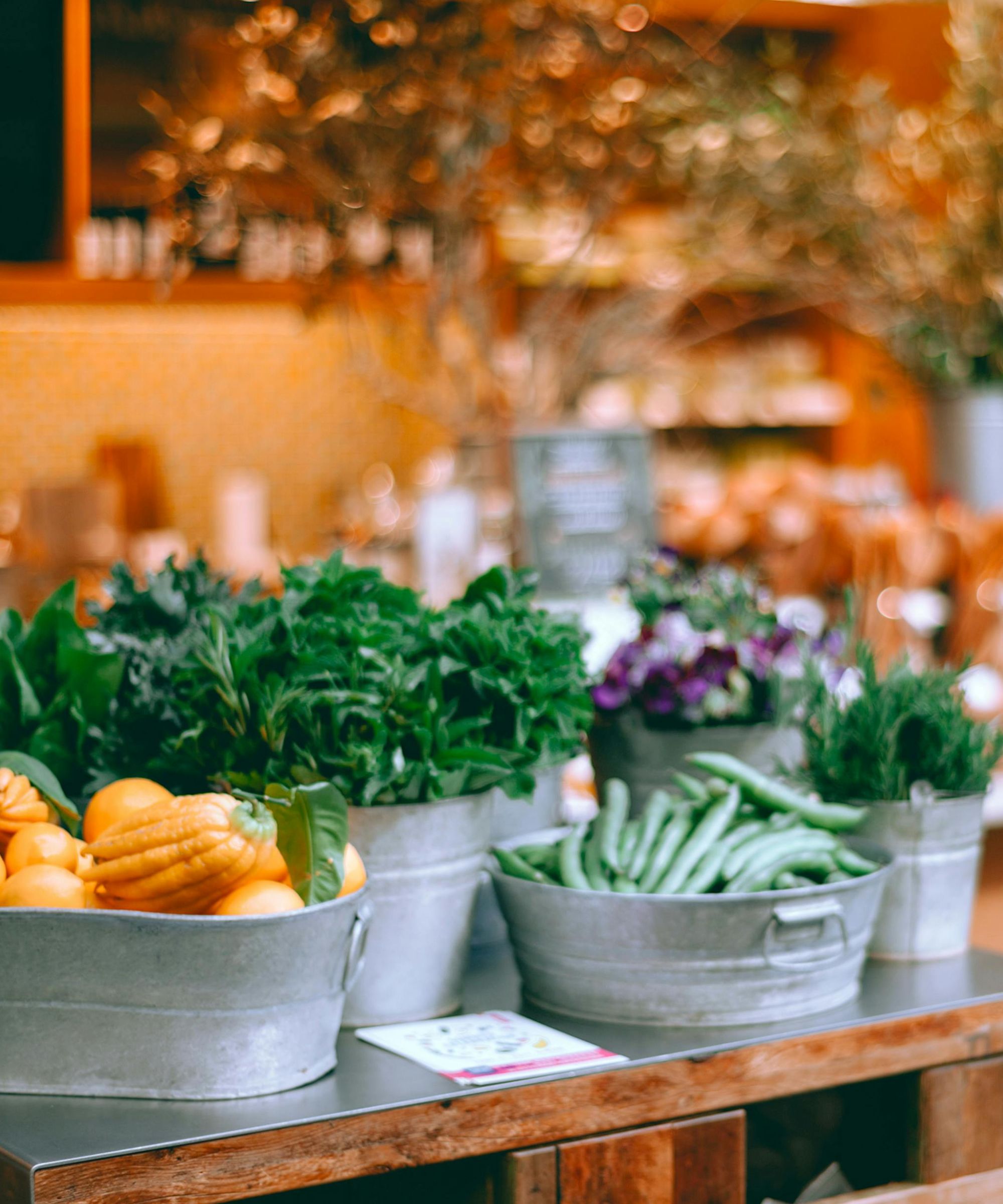 Tin buckets of herbs and gourds at a farmers market
