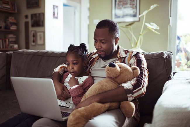 A father and daughter watching video on a laptop screen 