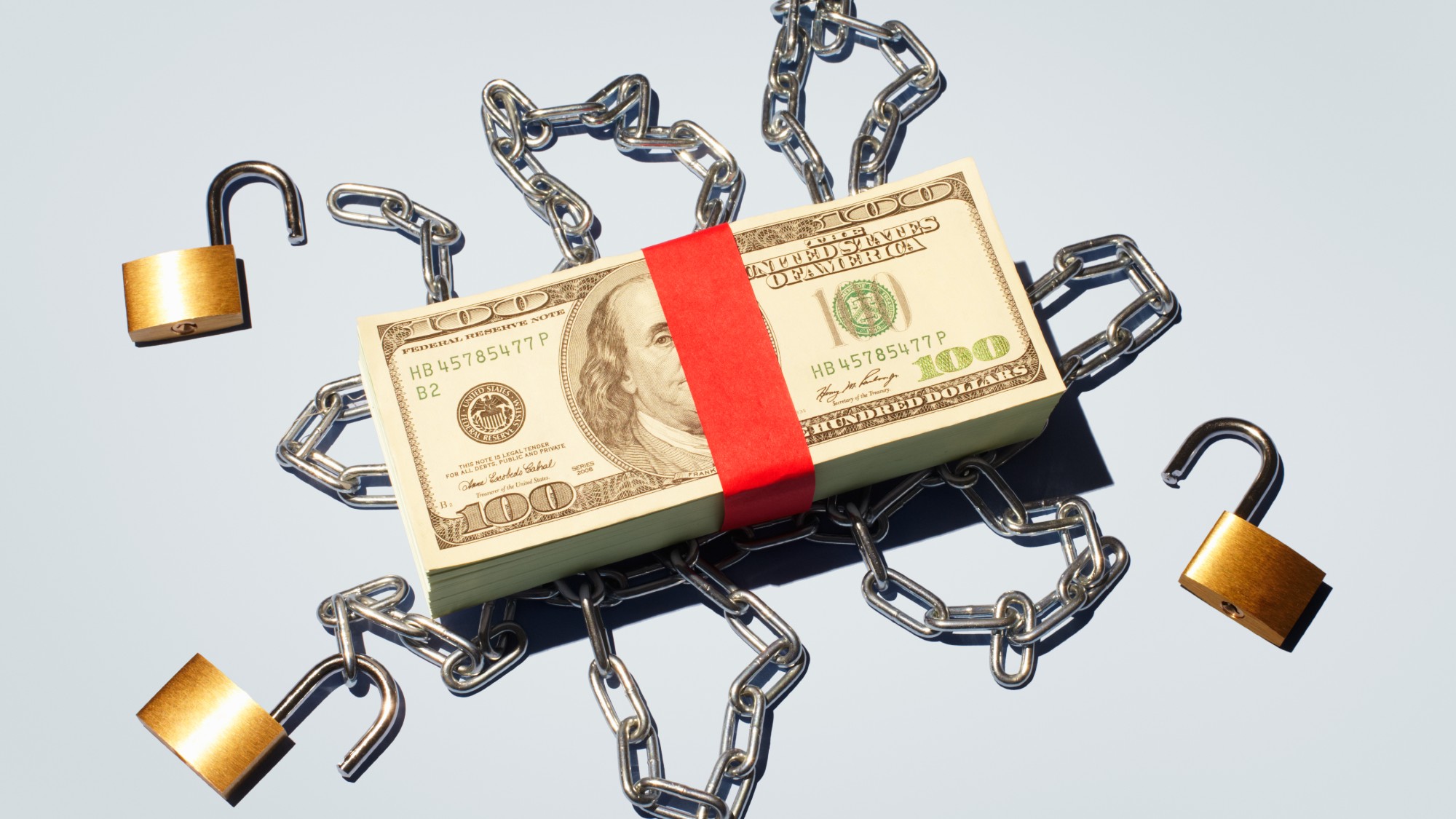 Stack of $100 bills enclosed in locks and chains