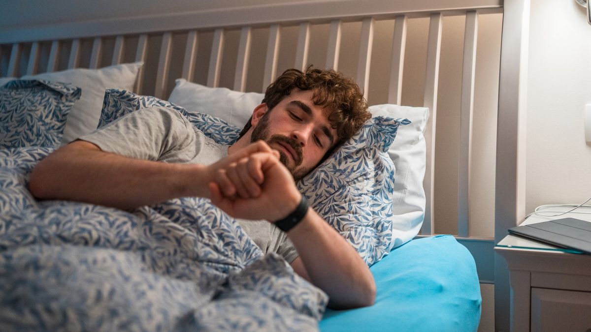 Man in bed checking smart watch