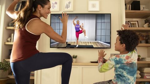 Peloton Digital review: A woman and child work out using the Peloton app on their TV