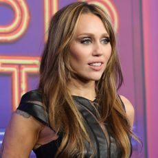 a close up of Miley Cyrus wearing a black top