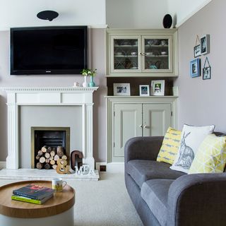 living room with tv and frames on white wall and couch