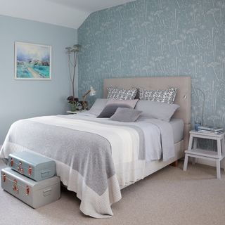 bedroom with grey designed wall and cream colour bed