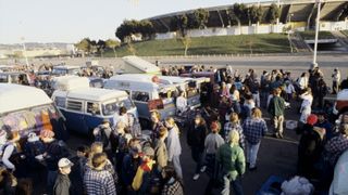 many people and vans outside large arena in Oakland