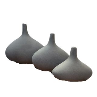 Three round gray vases in a curved row