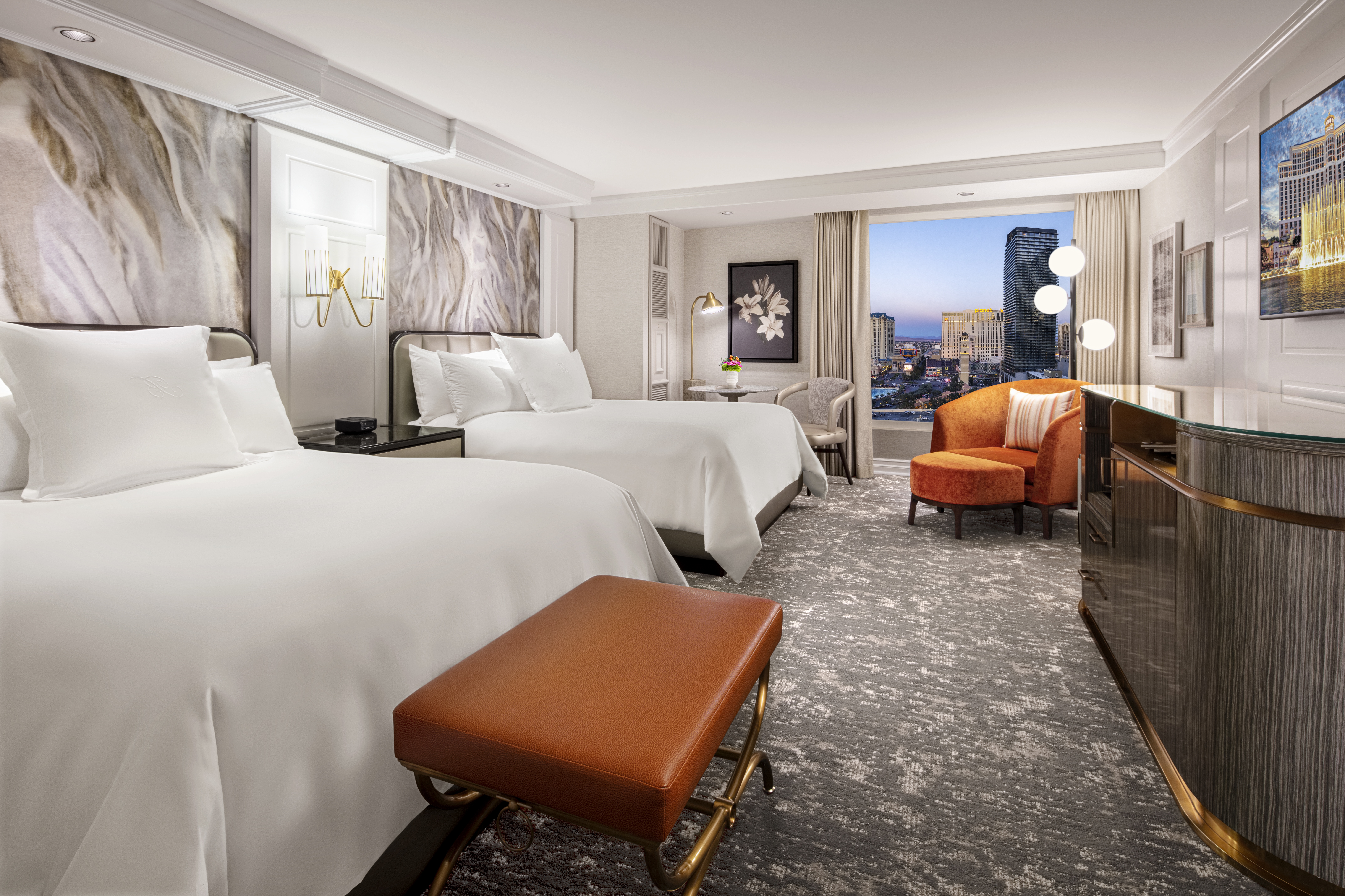 Two queen beds with white linens against marble headboards at Bellagio