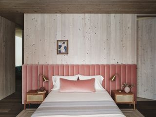 pink bedroom headboard against concrete wall