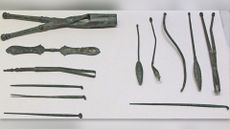 Ancient medical instruments displayed on a white background.