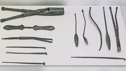Ancient medical instruments displayed on a white background.