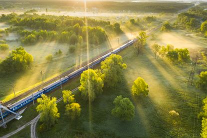 Aerial shot of train travelling through misty countryside