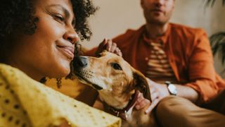 Woman sitting on couch with dog and man