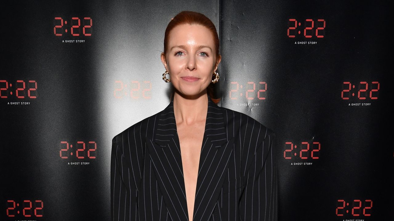 Stacey Dooley posing in a black pinstriped blazer at an event