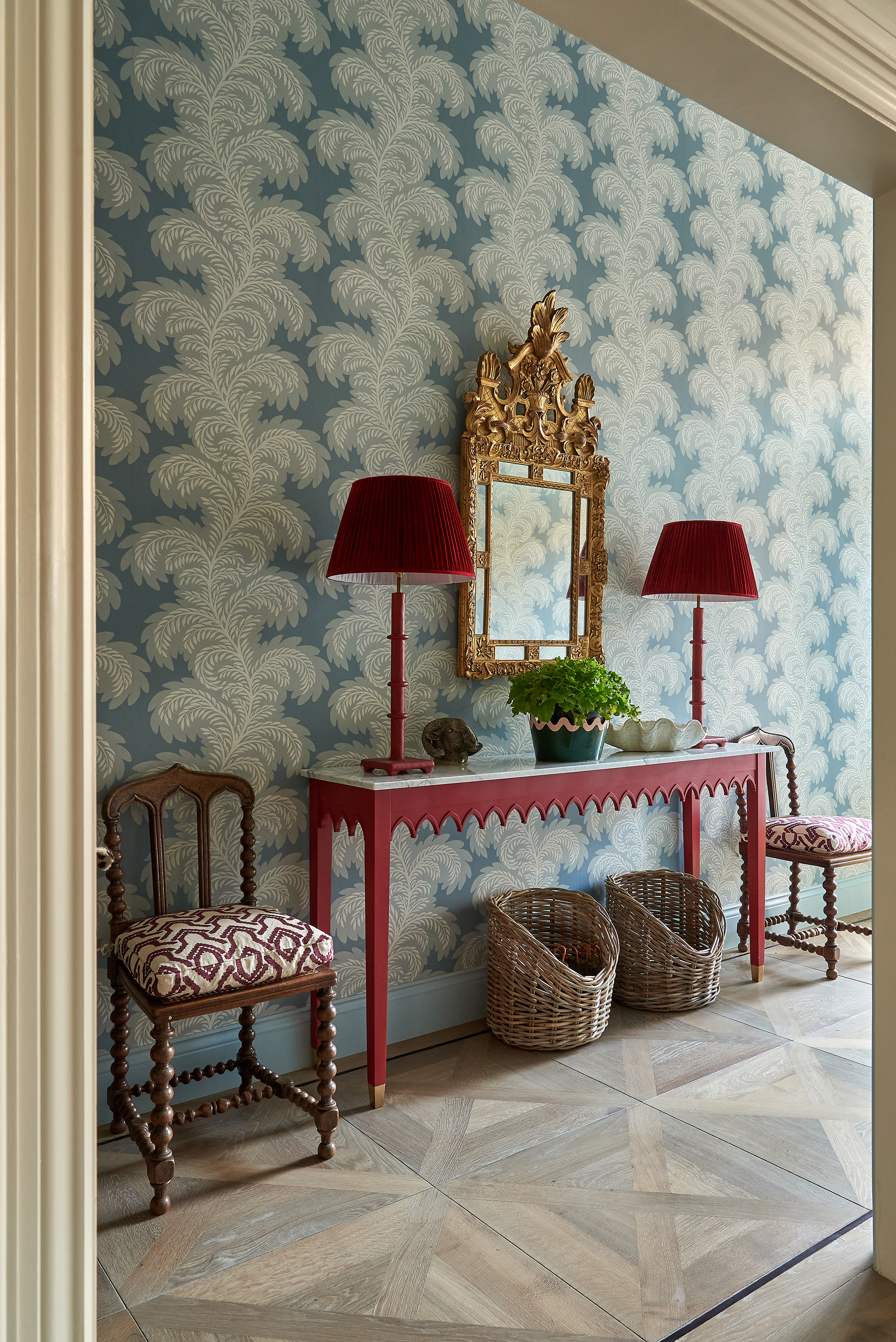 Red console table in a hallway with wallpaper