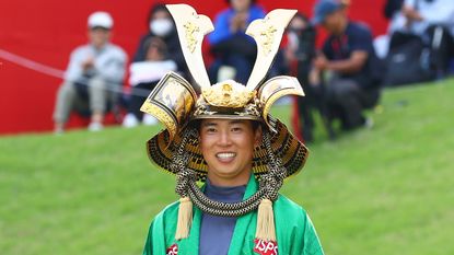 Yuto Katsuragawa celebrates wearing the ISPS Handa Championship trophy after his victory in 2024