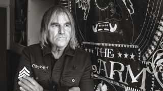 Mike Peters standing next to an Alarm flag