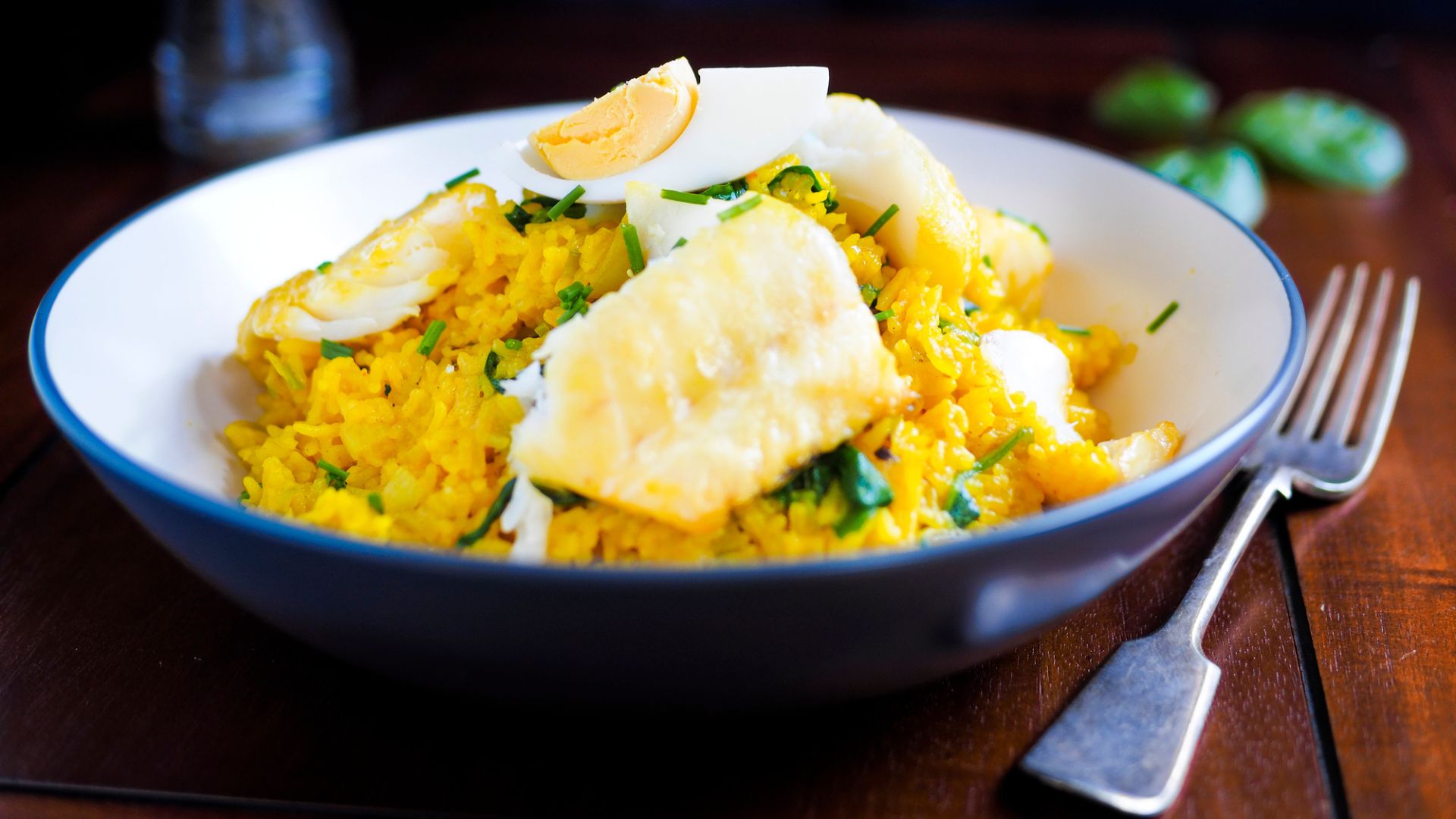 A bowl of kedgeree featuring boiled eggs, rice and fish