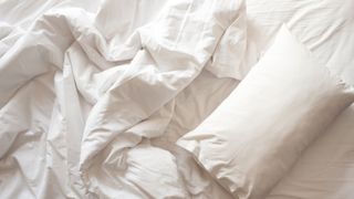 picture of pillow in unmade bed