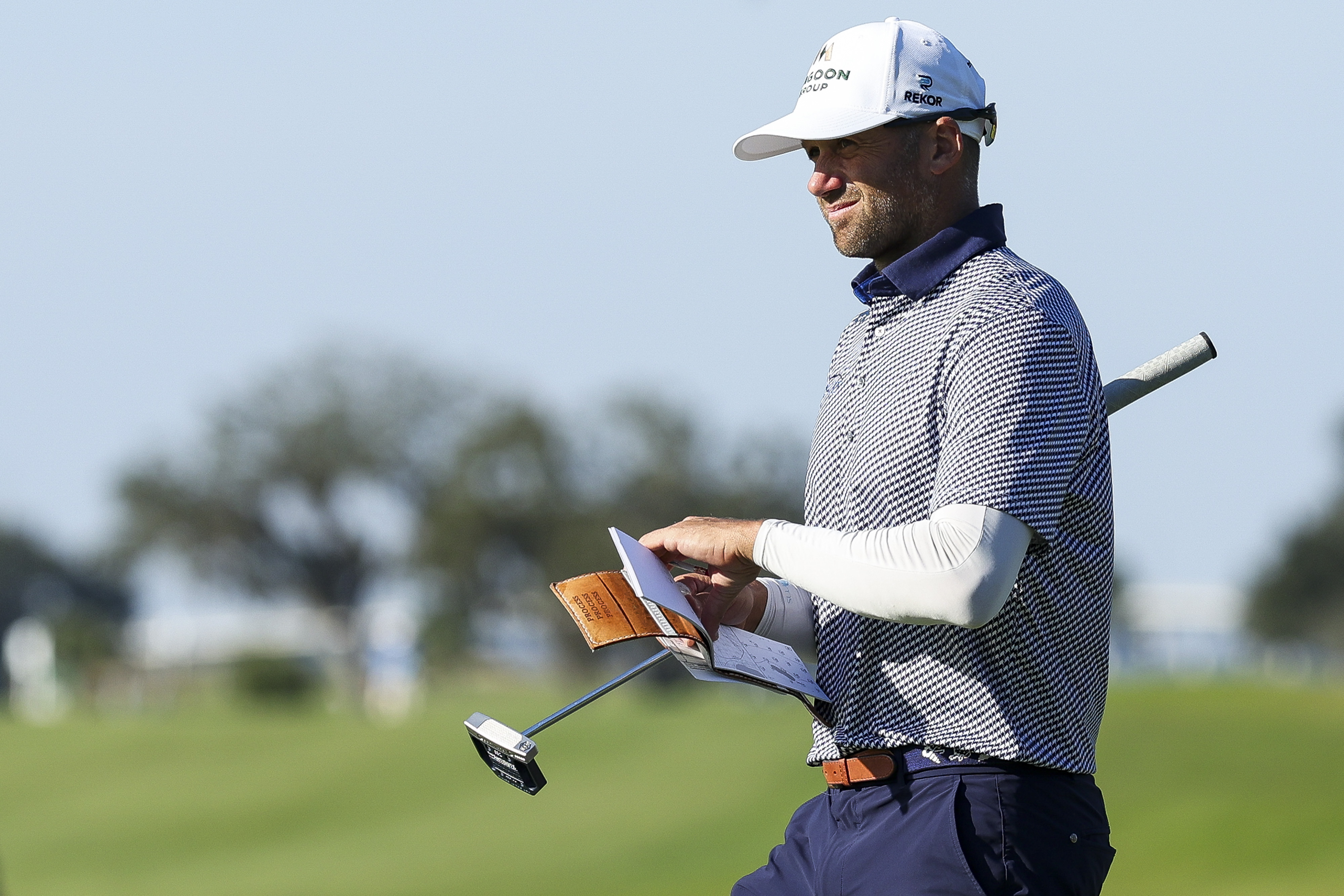 Ben Silverman walks off the green holding his putter