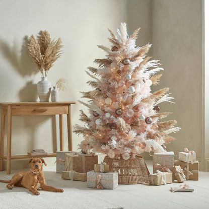 Cox & Cox Pampas Dreams Dusky Blush Christmas tree in a neutral living space next to a table and a dog