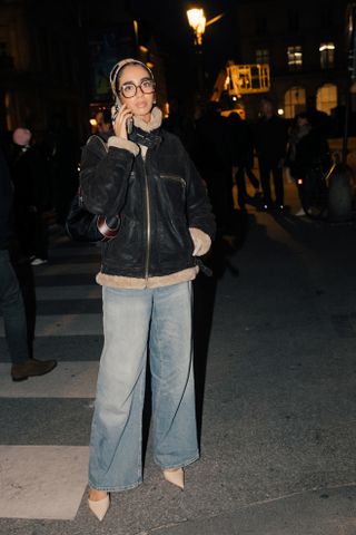 woman wearing shearling leather jacket, baggy jeans, and heels