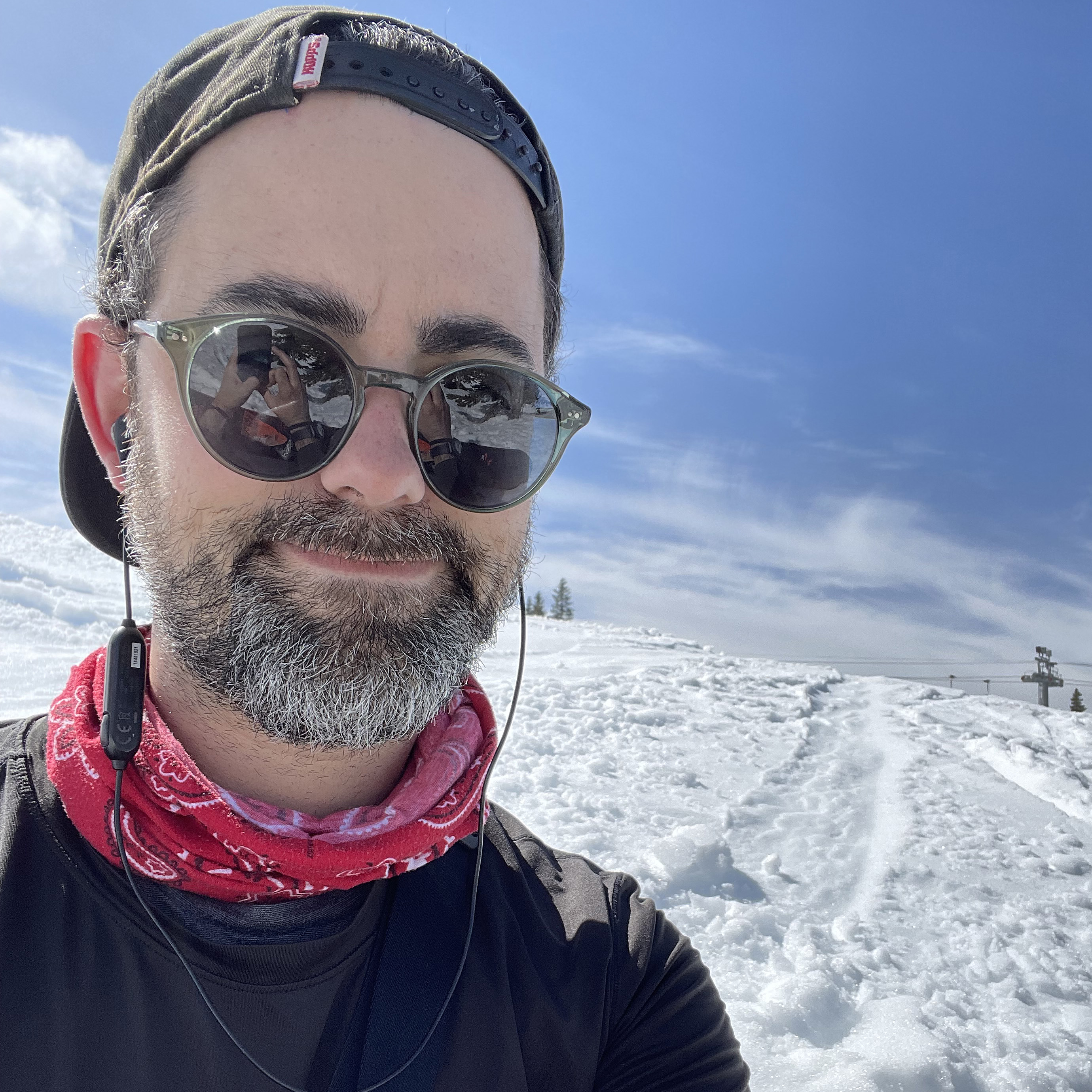 Author photo for Dan Bracaglia who's in sunglasses sitting on a snowy slope