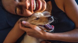 Reactivity in dogs - woman cuddling and smiling with her dog