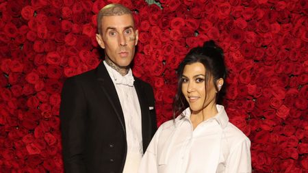 travis barker and kourtney kardashian on a red rose background