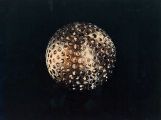Metallic ball regularly pockmarked with prisms