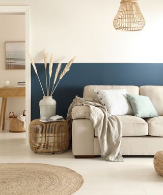 A beige and blue living room with a beige couch and a jute rug
