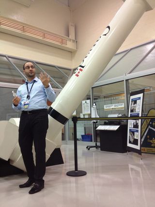 An engineering model of the robotic Canadarm sits in the CSA's "high bay" of equipment behind Mario Ciaramicoli, the agency's operations manager.