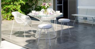 metal bistro table with a glass top with matching chairs to show mistakes when buying outdoor furniture