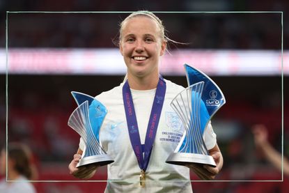 Lionesses player Beth Mead holding her trophies at Wembley Stadium after winning the Euros 2022 final