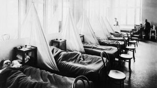 black and white photo of a row of beds in a 1918 flu pandemic ward during World War I.