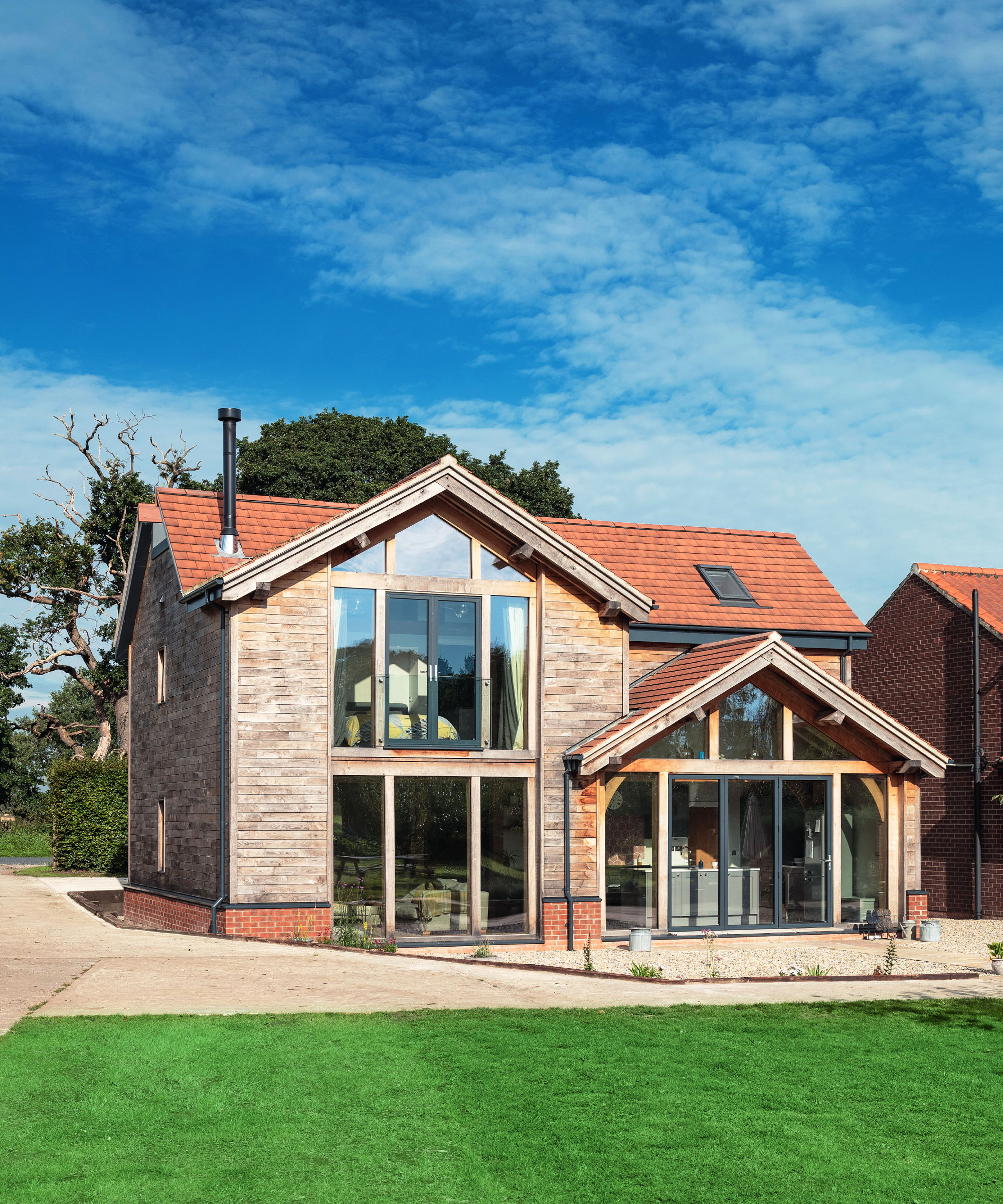 new build oak and stone home with large sections of architectural glazing