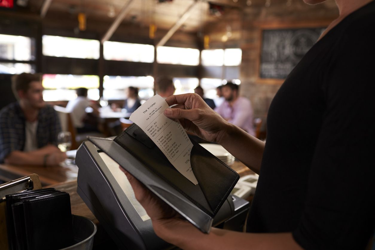 A waiter prepares a bill.